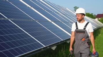 solar poder plantar com engenheiro dentro protetora vestuário de trabalho caminhando e examinando fotovoltaico painéis. conceito do alternativo energia e Está manutenção video