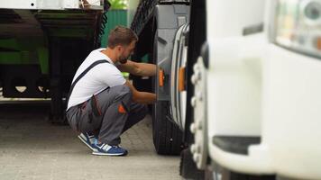 Professional mechanic using socket wrench while changing truck tire on car service video