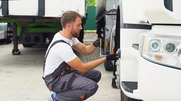 Truck driver using socket wrench while changing tire on car service video