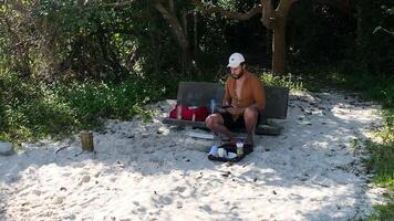 Man preparing and eating hot dog during picnic and walk at lake. video