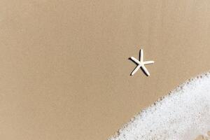 Starfish with white foam on sand beach, beautiful natural scene of tropical summer sand beach background for relaxing vacation, blue ocean waves crashing on sand beach island with copy space photo