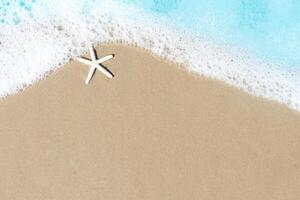 Starfish with white foam on sand beach, beautiful natural scene of tropical summer sand beach background for relaxing vacation, blue ocean waves crashing on sand beach island with copy space photo