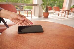 man hand picking up smart phone mobile to receive a call photo