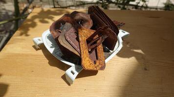A group of rusty mosquito coil holders on the table in the garden. photo