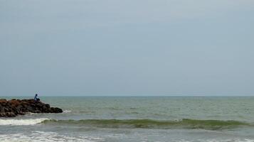Fisherman standing at the seashore photo