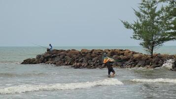 Fisherman standing at the seashore photo