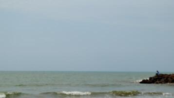 Fisherman standing at the seashore photo