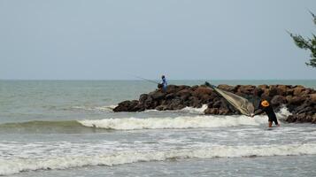 Fisherman standing at the seashore photo