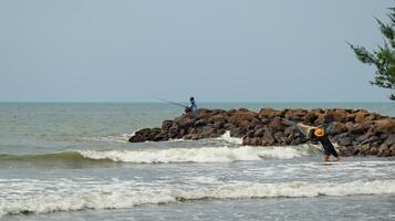 Fisherman standing at the seashore photo