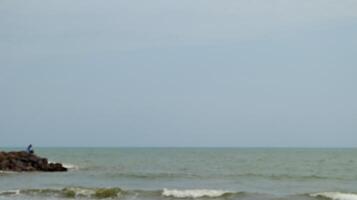 Fisherman standing at the seashore photo