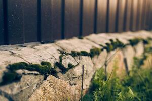 A new iron brown fence on a country plot in close-up with a stone foundation of cobblestones with space to copy photo