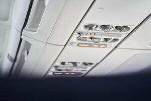 The buttons are located on the ceiling of a passenger aircraft, where safety elements such as an oxygen mask are located. With space to copy photo