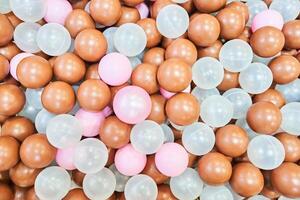 Colored plastic balls in the pool of the playroom in close-up. A children's party, a playroom, a box filled with small colored balls. With space to copy photo