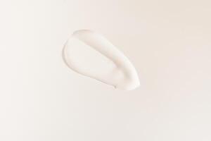 A smear of cosmetic cream. A white creamy drop of skin care cream. Fresh, smooth brushstroke isolated on a white background with space to copy photo