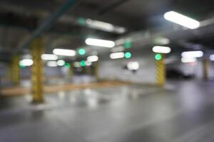 A blurred underground parking lot with a traffic lane sign, an unfocused traffic background, an unfocused snapshot of a parking lot in a shopping center. With space to copy photo