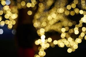 Abstract glowing bokeh lights highlighted on a black background. Festive golden glowing background with yellow lights. Overlay bokeh for your design photo