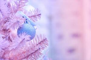 Part of a pink Christmas tree. Decorated with blue balls on fir branches with a blurred background photo