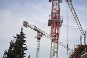 A working tower crane on large construction sites, and many cranes working in the field of new construction. Construction of an apartment building photo