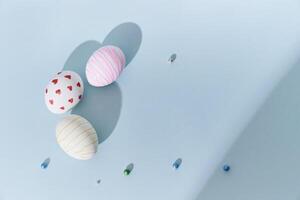 Close-up of three Easter eggs with a pattern of hearts and lines on a blue background. A shadow in the background. Top view with copy space photo