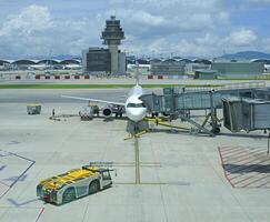 Airport terminal huge glass window with front view of air plane and air traffic control tower photo