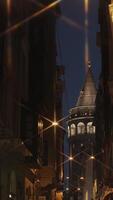 Nighttime view of Istanbuls Galata Tower with illuminated street lights and dark alleyways, ideal for vertical shot stories on TikTok and Instagram, capturing the mystical and historic essence of video