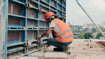 The builder fixes the metal structure on the construction site. Installation of metal structures for filling with a monolith. video