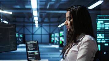 Computer scientist in data center monitoring security threats using PC, implementing cybersecurity measures. Server farm employee ensuring compliance with regulations, camera B video