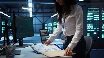 Programmer in data center arriving in office, being tasked with ensuring system can handle networking tasks. IT specialist in server farm starting job shift, tracking network traffic with PC, camera B video