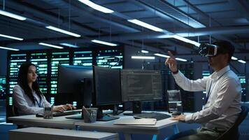 Data center admin responsible for installation of networking systems wearing high tech VR headset. IT worker doing maintenance on server farm gear using virtual reality technology, camera B video