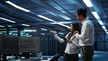 Team of technicians working on tablets in data center used for managing gear energy consumption. Teamworking colleagues using devices in workspace used for automation in server farm, camera B video
