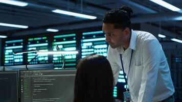 Team of admins in data center ensuring system can handle networking tasks. Teamworking colleagues in server room tracking network traffic with PC, making improvements, camera A video