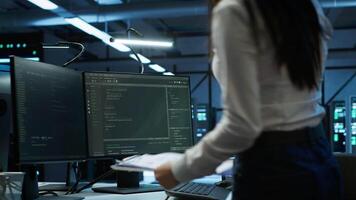 Engineer in data center installing software on computer, helping maintain network, troubleshooting arising issues. IT expert in server room establishing performance benchmarks, camera A video