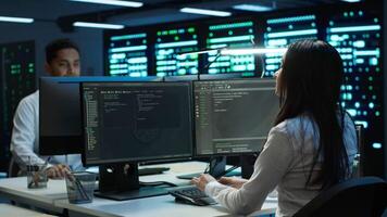Management executive in data center ensuring system can handle networking tasks. Coworkers doing brainstorming in server room, tracking network traffic with PC, making improvements, camera A video