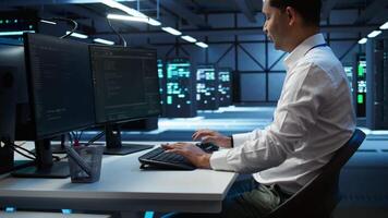 Engineer overseeing data center, making routine improvements and updates to ensure system can handle all networking tasks. Server room employee tracking network traffic and activity, camera B video