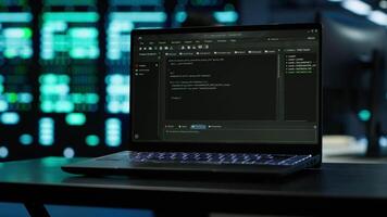 Focus on laptop used by engineers coding in modern data center, monitoring security threats. Close up of notebook used by employee in blurry background ensuring compliance with regulations, camera A video