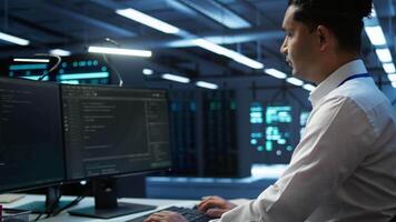 Portrait of smiling technician in data center implementing and managing infrastructure to ensure optimal performance and reliability. Happy IT specialist in server room coding on computer, camera B video