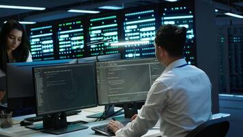 Coworkers in high tech data center monitoring security threats, implementing cybersecurity measures. IT staff members ensuring compliance with server room workspace regulations video