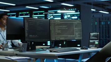Data center network engineer designing, implementing and managing infrastructure to ensure optimal performance and reliability. IT expert in server room coding on computer, camera A video