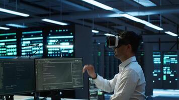 Admin in data center using virtual reality tech to ensure system can handle networking tasks. Server room worker wearing VR headset to track network traffic with PC, making improvements, camera A video