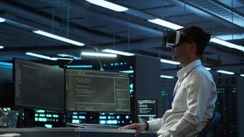 Programmer in data center managing and maintaining databases using futuristic VR headset, ensuring data integrity and security. Expert updating server room systems using virtual reality video