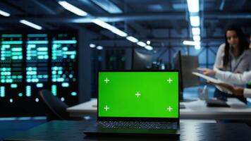 Focus on green screen laptop used by engineers in high tech data center to monitor security threats. Close up of mockup notebook used by workers ensuring compliance with regulations, camera B video