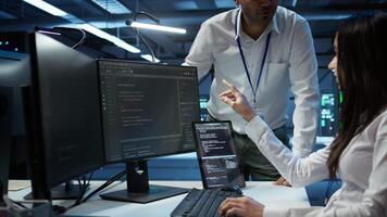 Team of admins in data center ensuring system can handle networking tasks. Teamworking colleagues in server room tracking network traffic with PC, making improvements, camera B video
