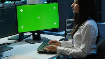System administrator in data center installing software on green screen computer, troubleshooting issues. IT expert uses mockup PC in server hub, establishing performance benchmarks, camera A video