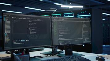 Computer displays in modern data center used for monitoring security threats threatening rigs. Panning shot of PCs used by high tech facility admins ensuring compliance with regulations video