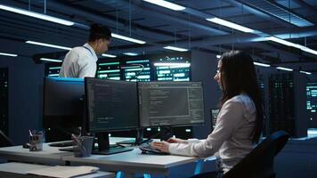 Computer scientists in data center managing and maintaining databases, ensuring data integrity and security. IT staff members updating server room systems using, camera B video