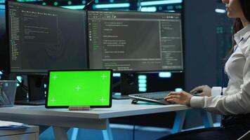 Data center developer responsible for installation of networking equipment solving tasks on green screen device. Woman doing maintenance on server room infrastructure using chroma key tablet, camera A video