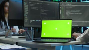 Admin in data center using isolated screen laptop to design, implement and manage gear, ensuring optimal performance and reliability. Expert in server room coding on chroma key notebook, camera A video