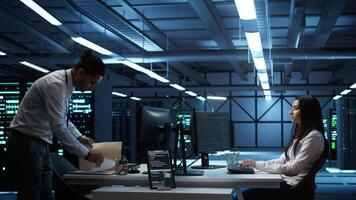 Teamworking colleagues in high tech data center managing and maintaining databases, ensuring data integrity, security and availability. Team of specialists updating server room systems, camera B video