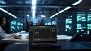 Focus on laptop used by engineers coding in modern data center, monitoring security threats. Close up of notebook used by employee in blurry background ensuring compliance with regulations, camera B video