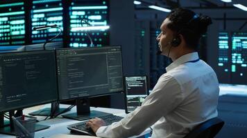 Data center agent providing logistics support to businesses and overseeing infrastructure. Server farm worker oversees hardware rackmounts and communicates with technicians, camera A video